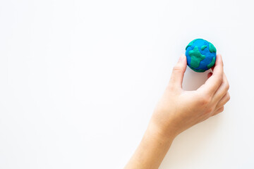 Plasticine globe planet Earth in hand - protection ecology concept