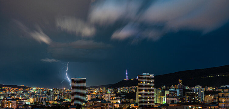 Dramatic sky with lightnings in the night over Tbilisi's downtown
