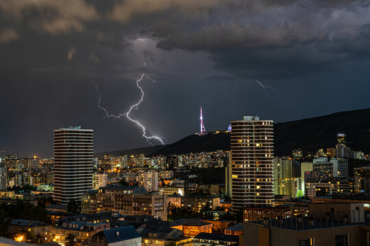 Dramatic sky with lightnings in the night over Tbilisi's downtown
