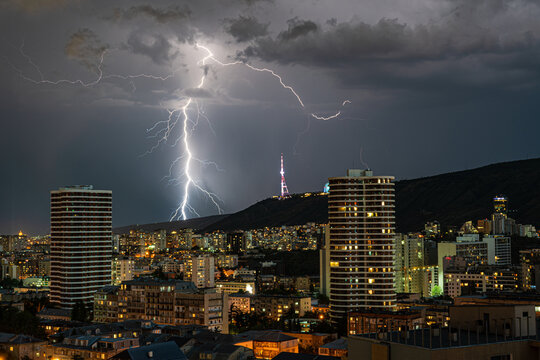 Dramatic sky with lightnings in the night over Tbilisi's downtown