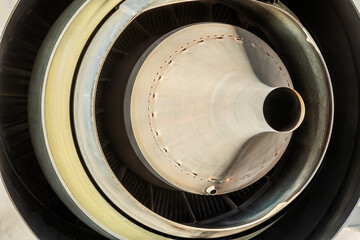 Close up of rear exhaust of a jet engine with yellow glow and spinner, sensor and fan blades...
