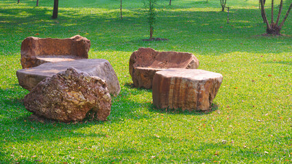 Natural stone garden table set decoration on green lawn in public park area © Prapat