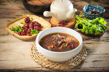 asian traditional double boiled herbal beef lamb meat red date hot healthy soup in bamboo basket on vintage wood table ingredient background Chinese halal food banquet menu for restaurant