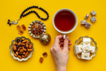 Muslim holiday concept - tea cups and Muslim rosary with a crescent moon