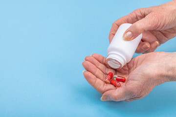 A woman takes medicine. Female hands hold capsules or pills. Treatment, taking vitamins, healthcare