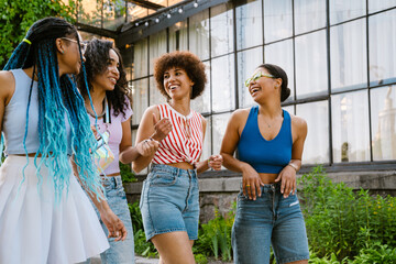 Group of cheerful women having fun while spending time in greenhouse