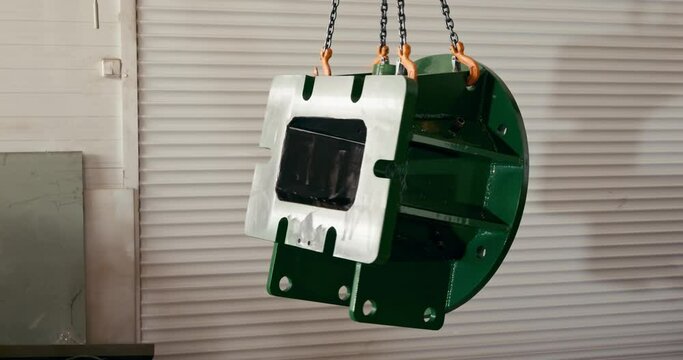 a large metal object hanging on a chain in a factory store