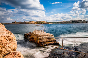 Stairs with railing into the sea. The surf splashes