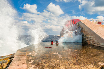 The surf splashes against the St Elmo Breakwater and the spray whips up to the St Elmo Bridge