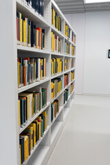 a large number of bookshelves with books. White bookshelves in the library, on which there are many books.