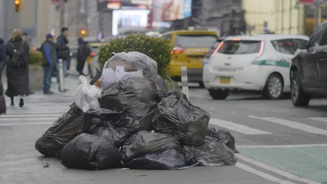 Bags of garbage pile up on a New York city sidewalk