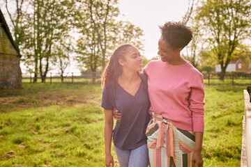 Mature Mother With Teenage Daughter Enjoying Walk In Countryside Together - Powered by Adobe