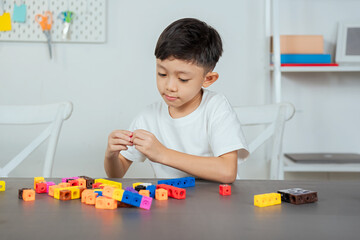 Asian boys playing with jigsaw puzzles in white room, Asian boys playing with plastic jigsaw puzzles for age development, educational materials for young children's learning development.
