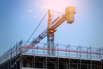Building under construction with scaffoldings and crane nearby, building site with framework and...