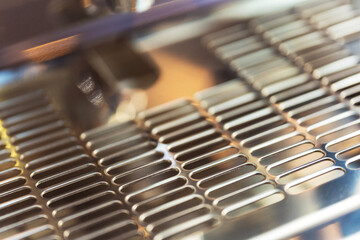 protective metal mesh on an industrial coffee machine. Drainage metal sheet with holes for draining liquids. corrugated stainless steel sheet on a coffee machine