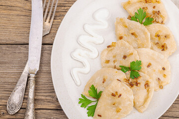 Dumplings, filled with cabbage. Fried onion, fresh sour cream. Traditional Ukrainian dish