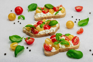 Fresh bread sandwiches with tomato cherry, cream cheese and basil leaves. Morning breakfast concept