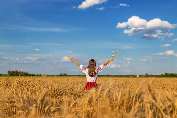 Ukrainian child in vyshyvanka in wheat field. Selective focus.