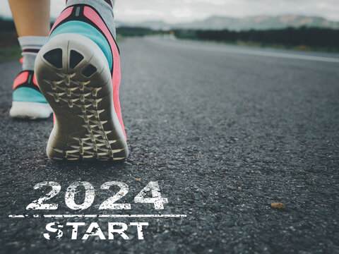 Taking off to start 2024. Female sprinter athlete preparing to run on the road with text on the road.