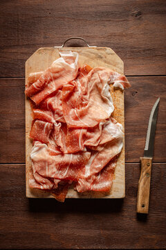 Slices of prosciutto di Parma on chopping board.