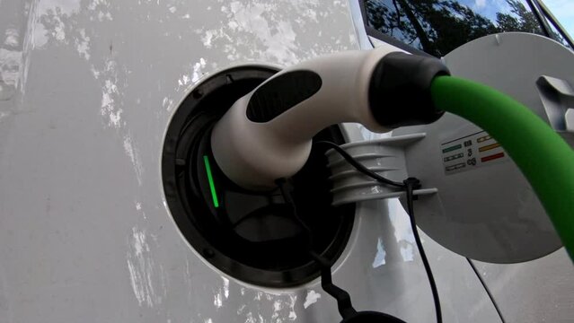 EV charging station for electric car in concept of green energy and eco power produced from sustainable source to supply to charger station in order to reduce CO2 emission .