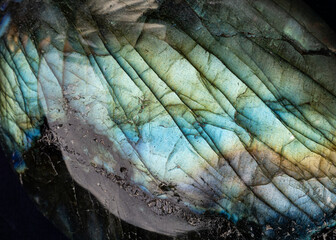 This is a colorful macro photo of a luminous and iridescent labradorite stone.  The patterns and otherworldly blue colors give it a science fiction landscape look. 