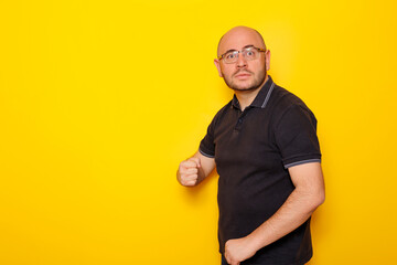 Funny man making faces on yellow color background
