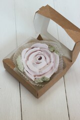 Homemade marshmallows in a paper gift box. Zephyr flowers. The box is open. Close-up.