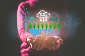 Hand holding virtual glob and sign CO2 reducing icon in concept of decrease carbon dioxide emission...