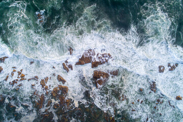 zenithal view of the waves on a rocky beach