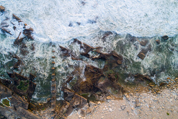 zenithal view of waves on a rocky coastline