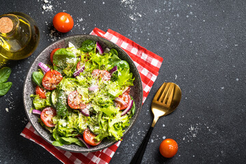 Green vegetable salad with fresh leaves . Top view at black background.