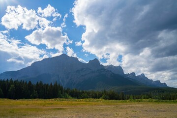 Fototapeta premium a view of a mountain with some trees and mountains behind