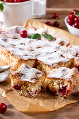 Sponge cake with cherries on a board on the table. Homemade pie