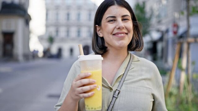 Young beautiful hispanic woman drinking bubble tea in the streets of Vienna