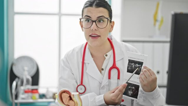 Young Beautiful Hispanic Woman Doctor Showing Ultrasound At The Clinic