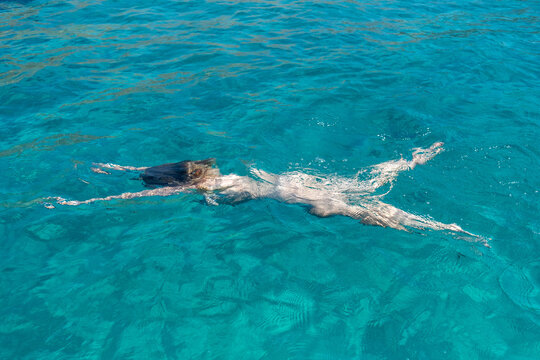 Im Urlaub nackt im k&uuml;hlen t&uuml;rkisen Meer schwimmen.