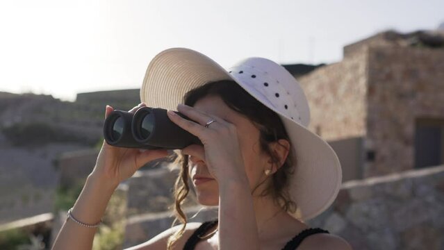 Portrait of a young woman using a binoculars.
