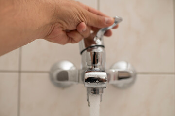 Tap water. Water pipes. The hand of a man lets water.