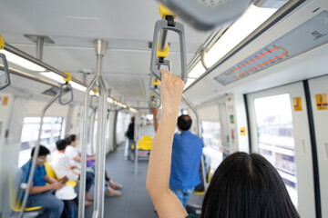 Woman hand firm grip safety handrail in elevated monorail train. Mass transit system in modern city. Inside of electric train. Tourist travel by city sky train. Public transportation. Urban transport.