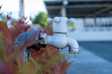 a dripping water faucet in a park in Indonesia,world water conservation day concept