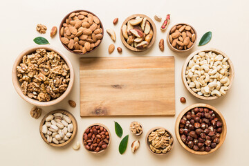 mixed nuts in wooden bowl. Mix of various nuts on colored background. pistachios, cashews, walnuts, hazelnuts, peanuts and brazil nuts