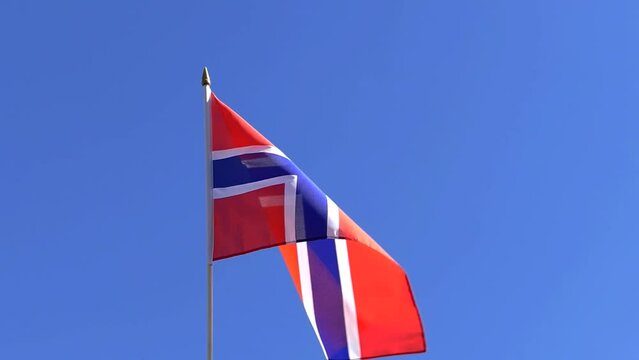 The Norwegian flag waving in the wind in the blue sky