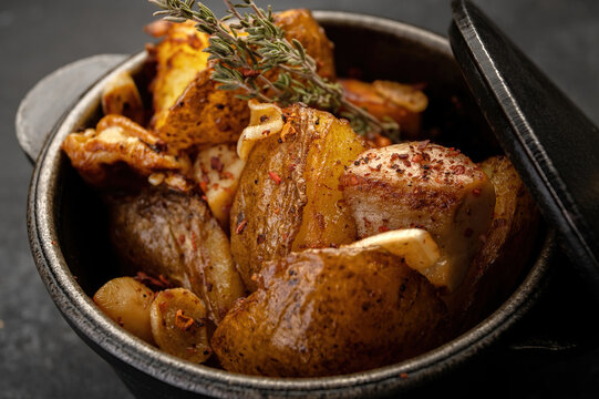 Fried Potatoes With Garlic And Spices In A Small Cast-iron Pot. Close-up