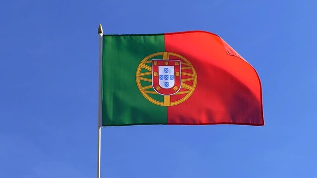 The Portuguese flag waving in the wind in the blue sky