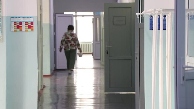 a sick woman in a danger zone walks along the corridor in the hospital