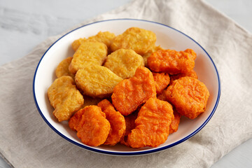 Homemade Spicy Chicken Nuggets Mix on a Plate on a gray background, side view.