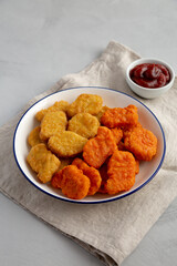 Homemade Spicy Chicken Nuggets Mix with Ketchup on a gray background, side view.