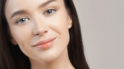 Fototapeta premium Closeup portrait of beautiful young white woman on gray background