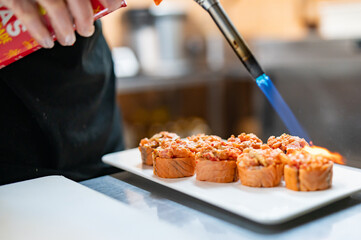 professional chef's hands making sushi roll in a restaurant kitchen